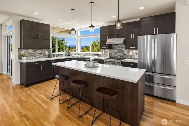 Chef's kitchen with stainless steel appliances & large island with seating