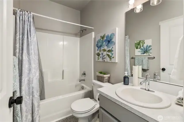 Modern and pristine full bath with stylish fixtures and a closet (not shown) behind the door.