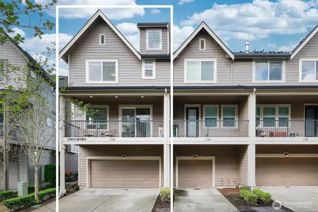 Back of home with covered deck and two-car garage at the ground level.