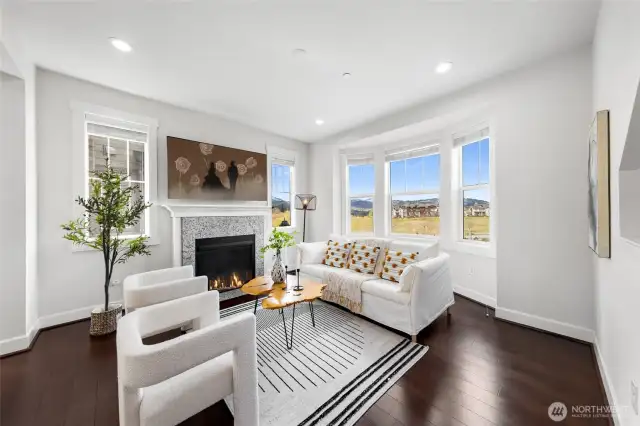 Living room with large windows and gas fireplace.