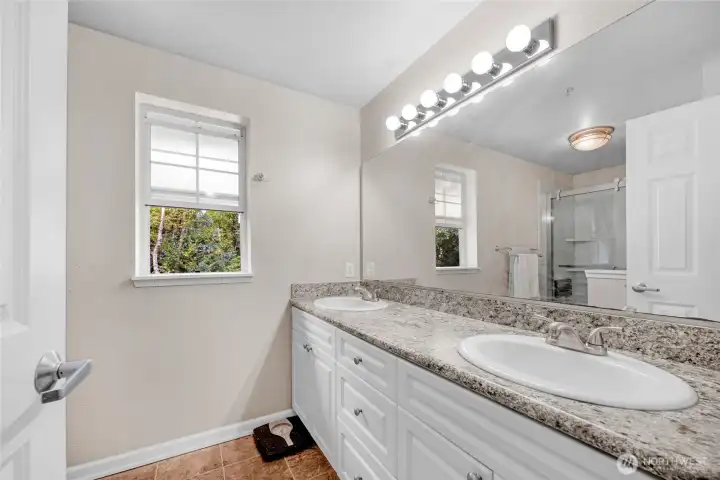 Primary bathroom with new walk-in shower and granite countertops.