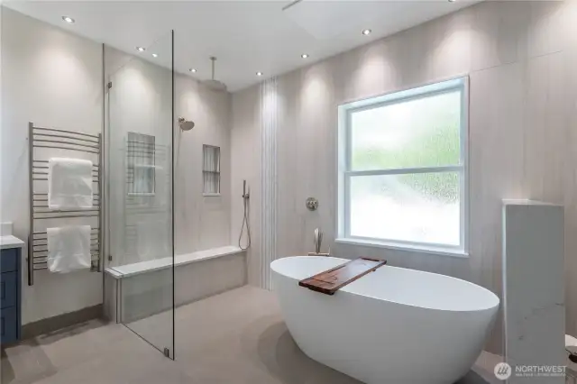 The shower floor and bench are heated utilizing a wifi thermostat, as well as the infrared heat panel above the soaking tub. The dimmable LED ceiling lights are also on Wifi controls. There is a heated towel bar on the wall next to the shower.