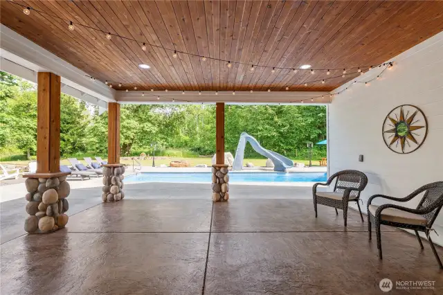 The large covered area just outside the great room, kitchen, and primary bath with cedar soffits