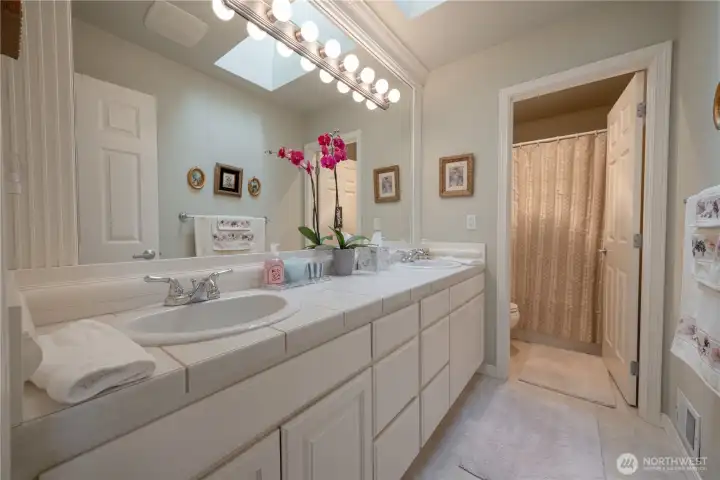 The upstairs full bath offers plenty of storage with double sink vanity.