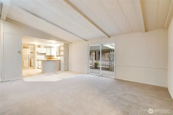 This view highlights the open floor plan—ideal for entertaining or everyday living. Sliding glass doors lead directly to the covered carport for easy access.
