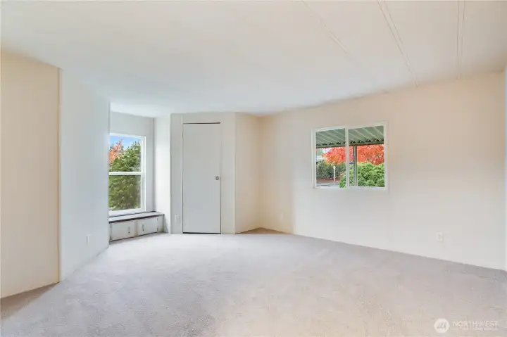 A bright second bedroom features a walk-in closet and a charming built-in window seat with extra storage.