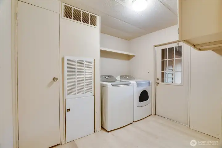 The functional utility room includes washer/dryer and even more storage, with a door leading to the carport.