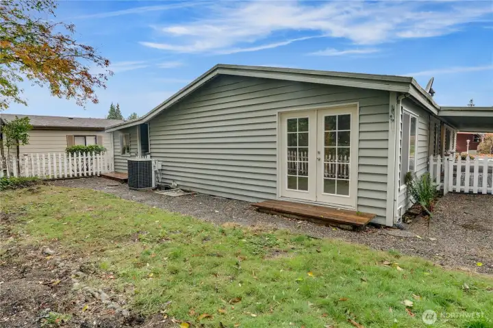French doors from the primary suite open to a fully fenced backyard with endless possibilities for gardening or outdoor living.