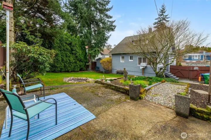 Rear patio with garden space and gently sloping yard.