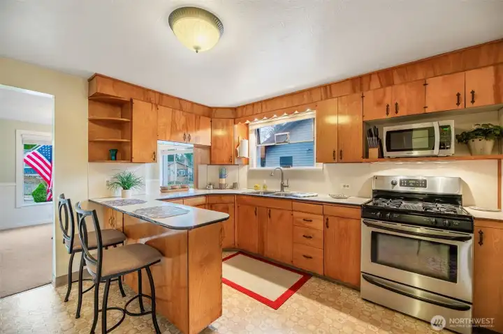 Pass through window to the dining room, dual compartment stainless steel sink.  Stainless gas cooktop and SS refrigerator freezer.  All appliances stay.