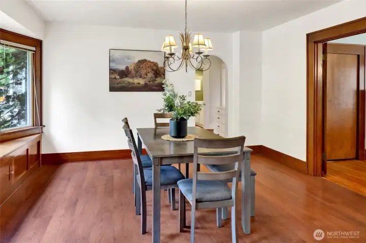 The dining room is filled with natural light from a charming bay window, complete with built-in storage below. Spacious enough to gather a crowd, it's the perfect spot for hosting memorable meals.