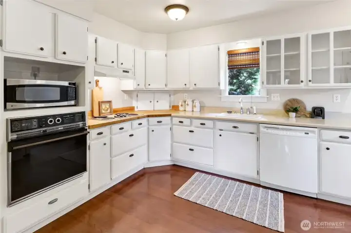 A functional kitchen with plenty of built-ins, a pantry, and a cozy breakfast nook. For those dreaming of a remodel, opening the wall to the dining room would create a spacious, flowing layout.