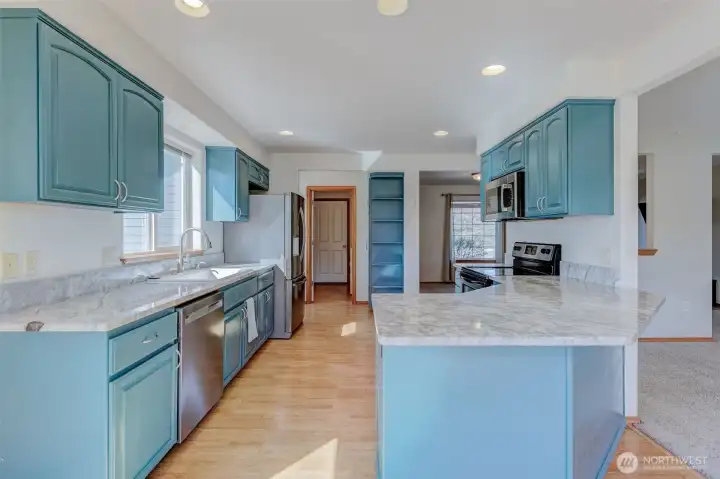 Updated kitchen with painted cabinetry, granite countertops, farmhouse basin sink, and generous prep space.