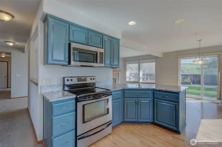 Updated kitchen with painted cabinetry, granite countertops, farmhouse basin sink, and generous prep space.