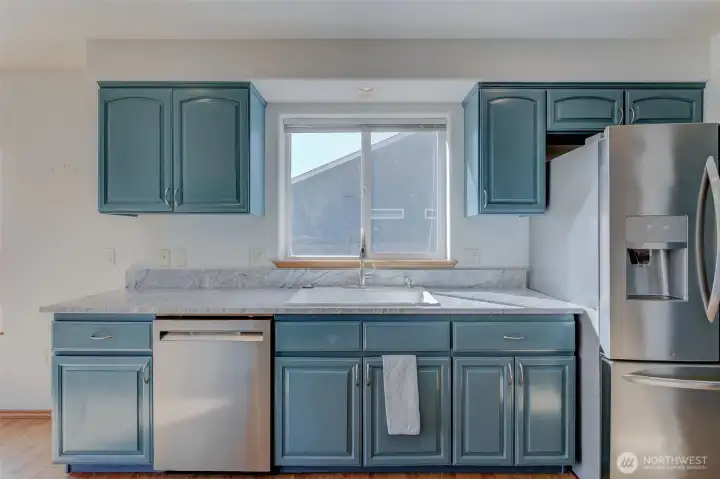 Updated kitchen with painted cabinetry, granite countertops, farmhouse basin sink, and generous prep space.