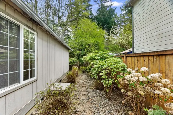 Stone pathway on right side of home with gate to access rear yard.