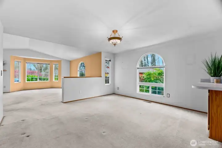Dining room view towards living room with arched window.