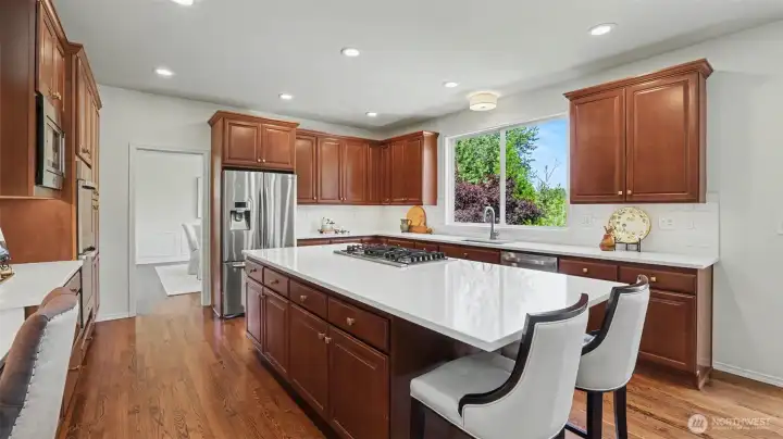 Gorgeous kitchen remodel with quartz countertops and designer tile backsplash, featuring a Bosch 5-burner cooktop. Gorgeous kitchen remodel with quartz countertops and designer tile backsplash, featuring a Bosch 5-burner cooktop.