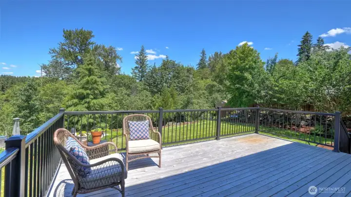 New cedar deck with modern black metal railing overlooks the private backyard. New cedar deck with modern black metal railing overlooks the private backyard.