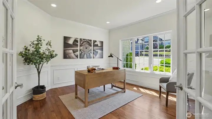 Off the entry, this main floor den is adorned with wainscoting, hardwood floors, and French doors. Off the entry, this main floor den is adorned with wainscoting, hardwood floors, and French doors.