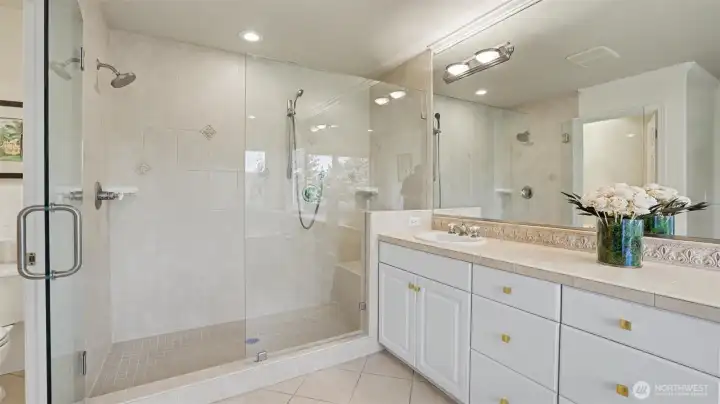 New spacious glass-enclosed spa-like shower with dual shower heads and bench seat New spacious glass-enclosed spa-like shower with dual shower heads and bench seat
