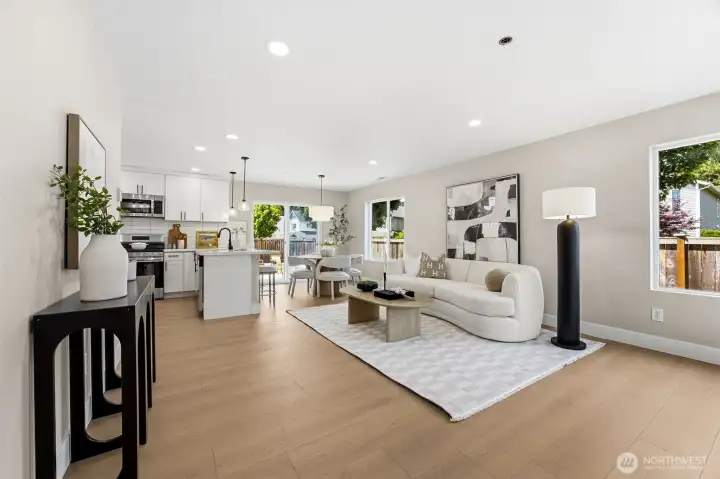 Large open concept family room with new flooring, paint, trim and lighting.