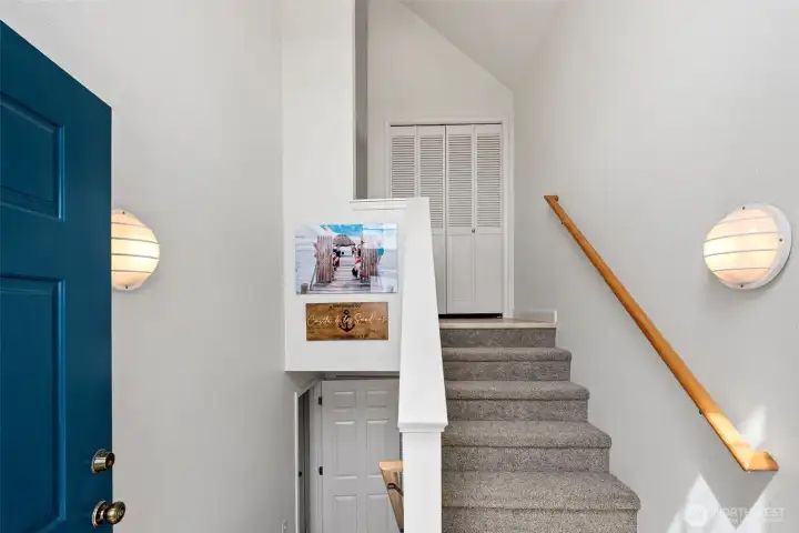 Split entry way with vaulted ceiling and large window for natural light.