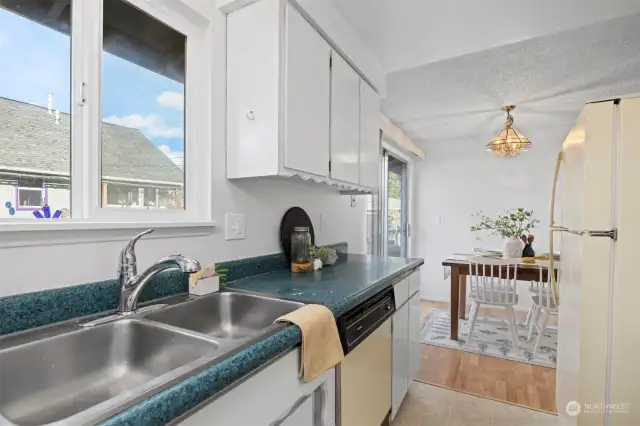 The sunshine streams in through the kitchen window that looks to the side yard.