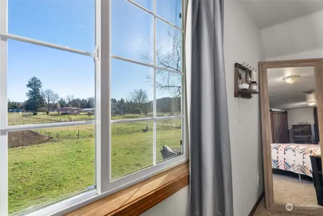 Primary bedroom overlooks the outdoor arena and pastures.