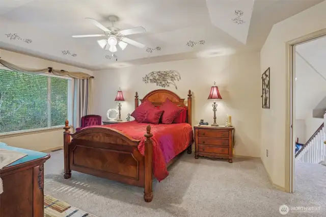 Primary bedroom with coffered ceiling and fan.