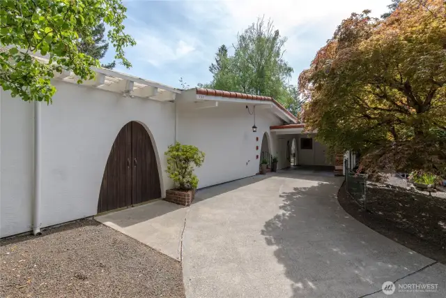 Driveway pulls into covered parking with EV charging station.