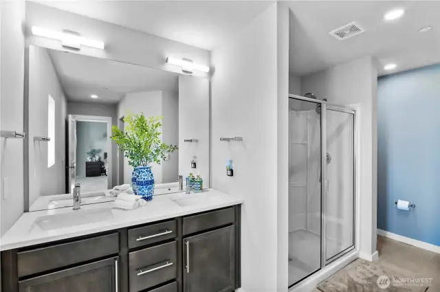 Primary Bath features double vanity, large shower, & hidden comode.