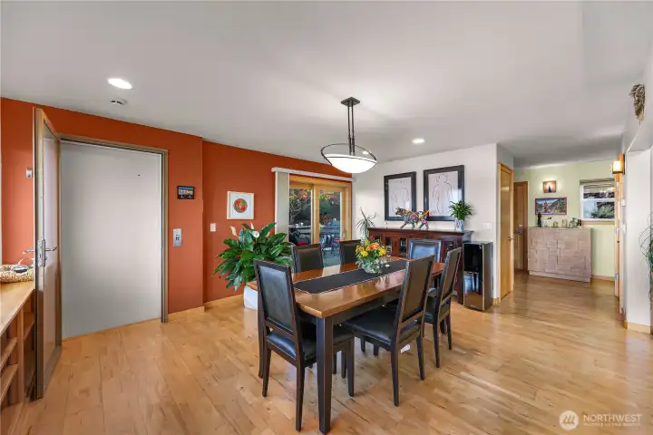 Expansive dining area with plenty of room for gatherings and entertaining, leads to large patio through sliding door and access to elevator