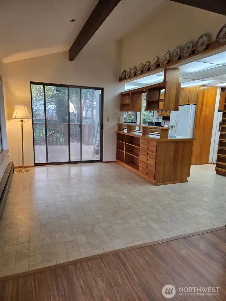 Living room looking into dining and kitchen area, with sliding doors out to covered deck.