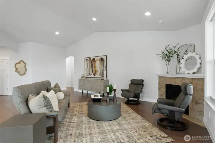 Another view of the living area, the arched doorway in the back leads to the primary bedroom, the 2nd bedroom and laundry room with access to the garage.