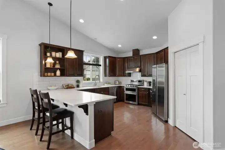 The generous kitchen offers a breakfast bar, pantry, all stainless steel appliances and abundant cupboard and counter space.