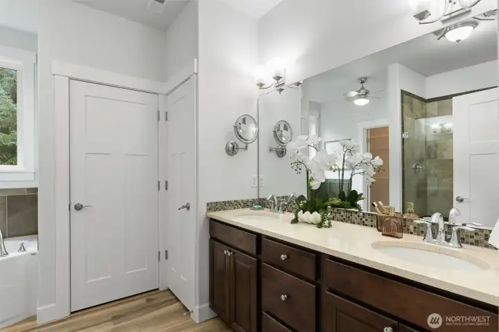 The en suite full bathroom with double vanity, shower, soaking tub, linen closet and separate toilet room.