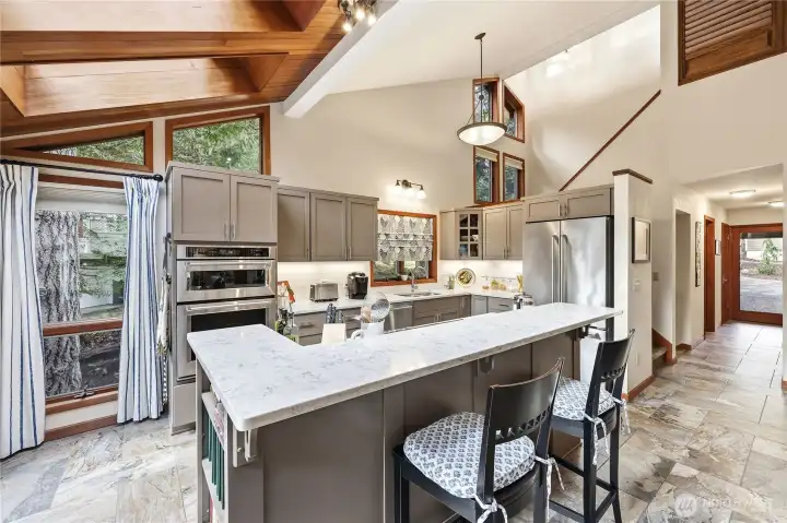 A beautifully redone kitchen with all newer stainless appliances, tile floors, and quartz countertops.