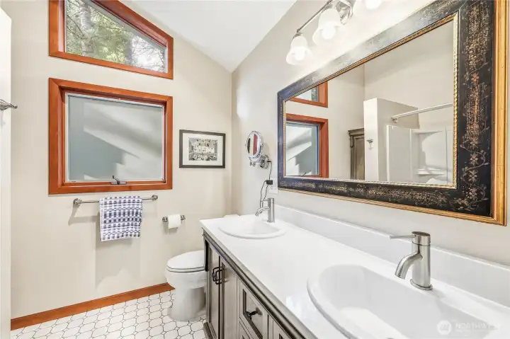 The renovated full bath on the upper level adjacent to the primary bedroom. Note the twin sinks.