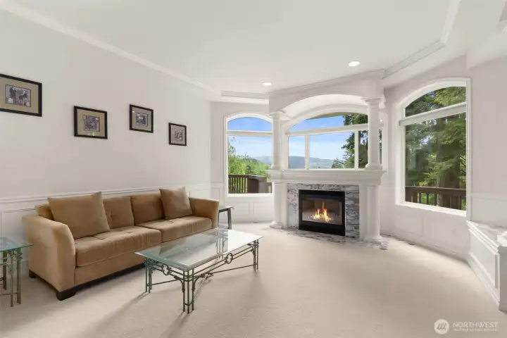 Formal living room with view of pastureland and lake.