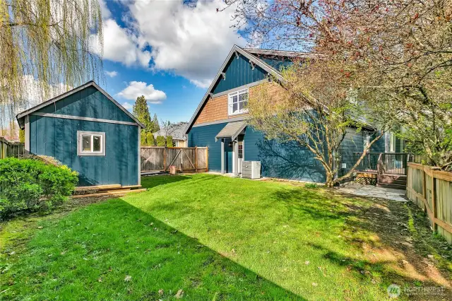 The fully fenced backyard, situated next to the expansive covered deck, is an ideal spot for a friendly game of badminton. It also includes a matching shed, perfect for keeping all your outdoor tools and equipment neatly organized and within easy reach.