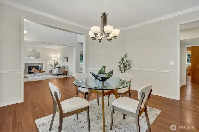 Spacious formal dining room showcasing beautiful hardwood floors. Butler's pantry conveniently located through the doorway to the right.