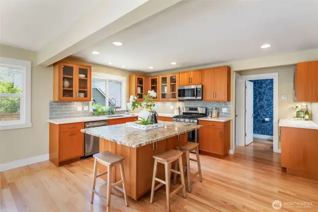 The spacious kitchen shines with warm wood cabinetry, quartz counters, and a large island perfect for prep or casual dining.