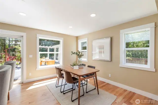 Enjoy casual meals or morning coffee in this bright breakfast nook framed by windows and garden views.