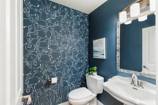 The stylish powder room features hand painted wall by Sandra Mackie for a polished feel.