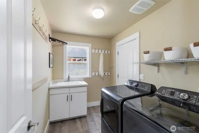 Convenient main-level laundry room with built-in storage and utility sink makes everyday chores a breeze.