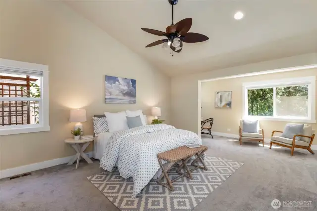 Retreat to the serene main-floor primary suite with vaulted ceilings, soft natural light, and tranquil views.