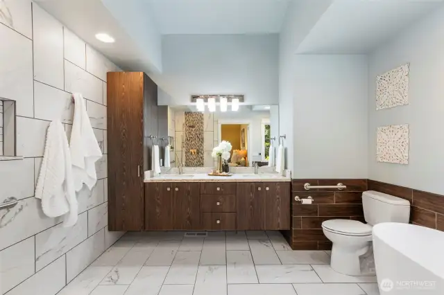 Unwind in the luxurious ensuite bath with dual vanities, warm wood cabinetry, and elegant finishes.