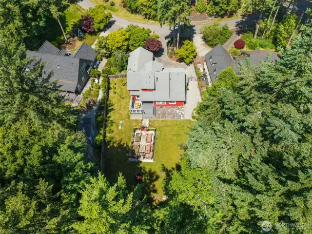 Bird’s-eye view of the home reveals the expansive lot, mature trees, and peaceful natural setting.