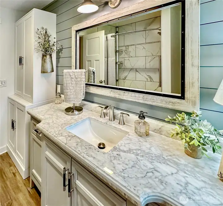 Updated hall bath with charming ship lap accent wall. Sweet vanity and storage cabinet.